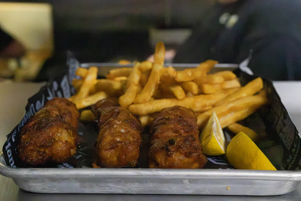 Three pieces of CJ’s fried cod with fries and lemon