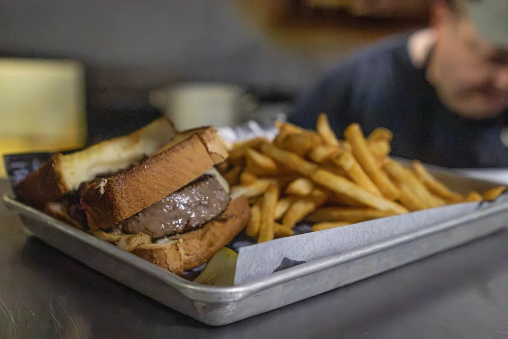 CJ’s beef patty melt on toasted bread with Swiss cheese and fries