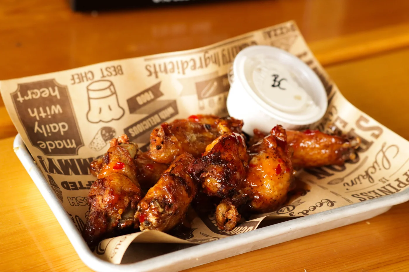 CJ’s glazed chicken wings served with dipping sauce